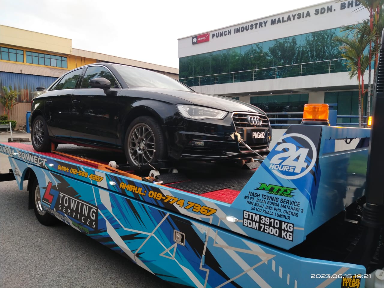 47 Towing flatbed transporting a black Audi